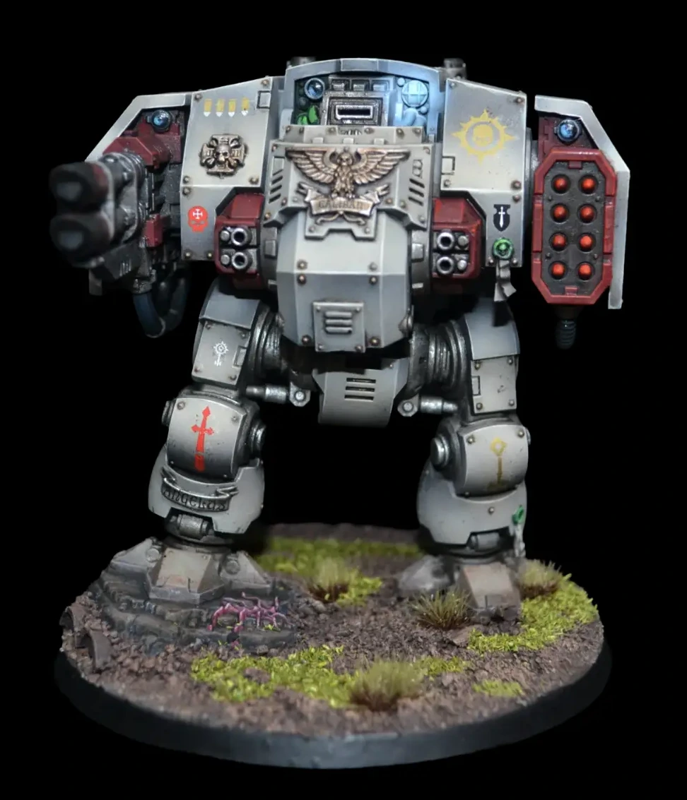 Ballistus Dreadnought in heller Rüstung mit roten Waffenverkleidungen, feinen Abzeichen und blauem Leuchteffekt auf begrünter Base