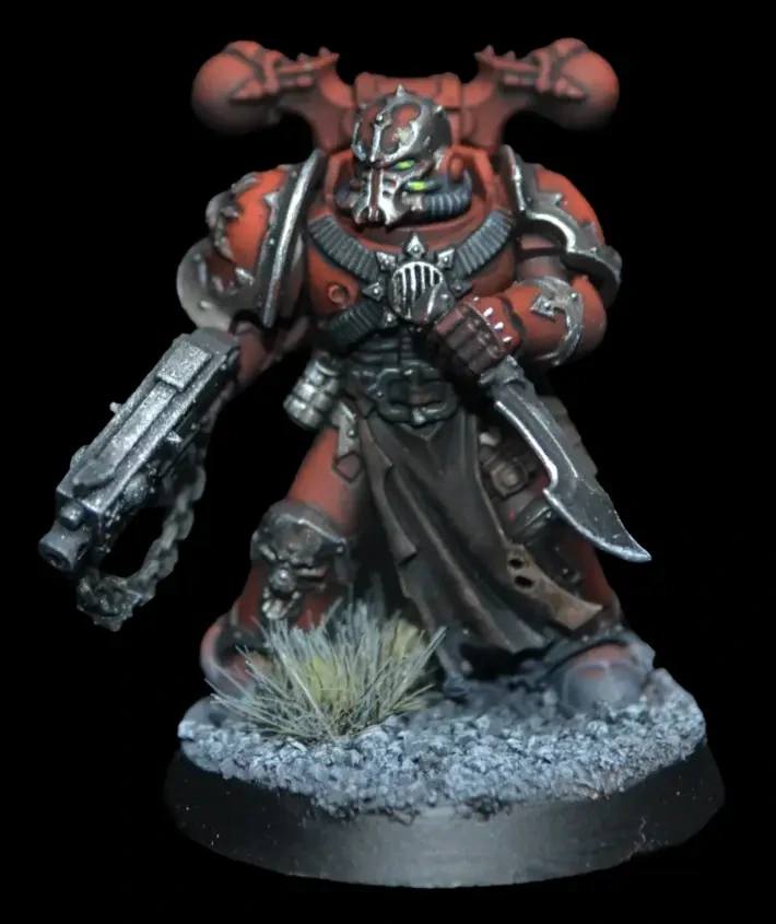 Word Bearers Chaos Space Marine in roter Rüstung mit silbernen Details und dunklem Wappenrock auf felsiger Base