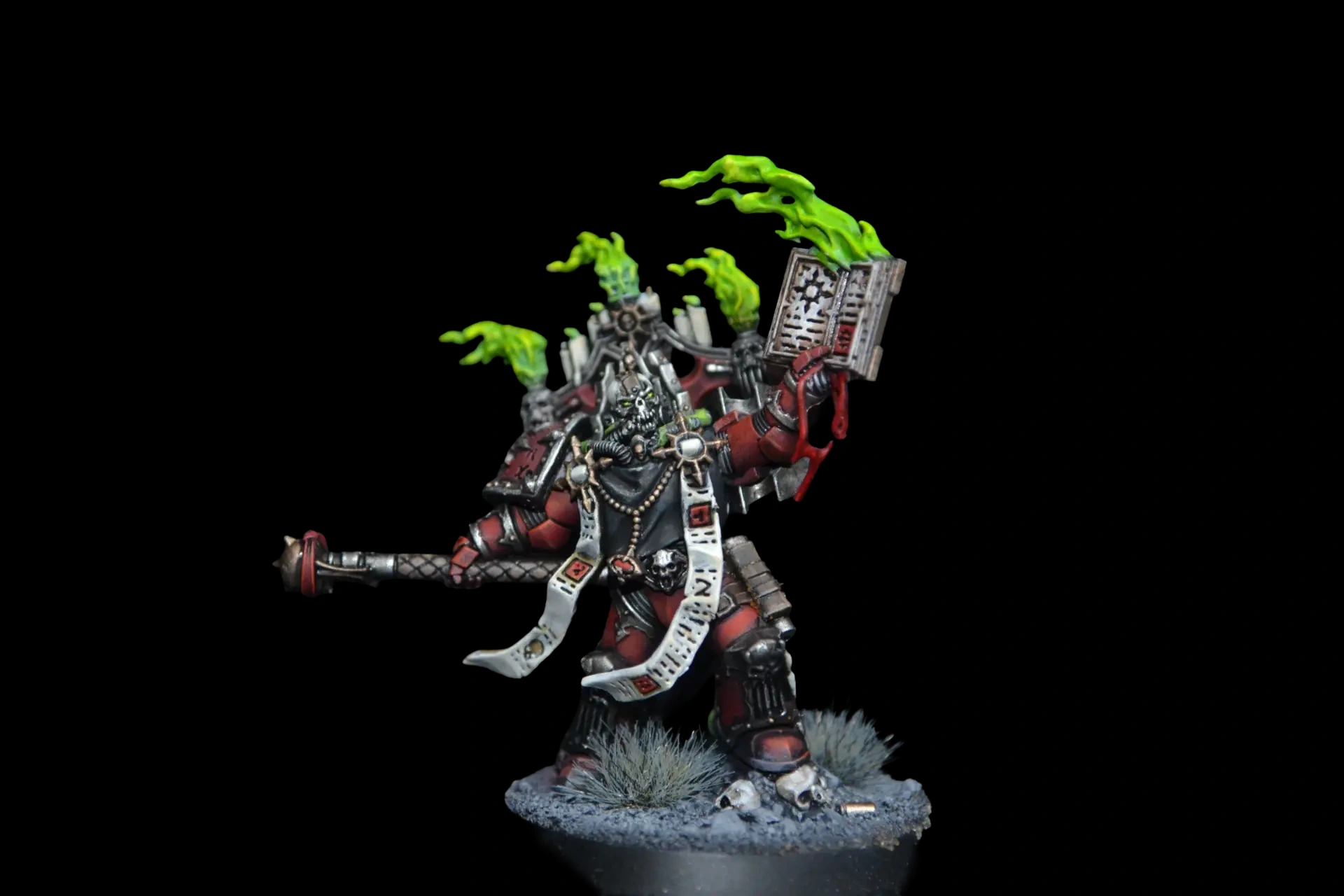Word Bearers Dark Apostle in roter Rüstung mit grünen Flammen, Schriftrollen und erhobenem Buch vor schwarzem Hintergrund